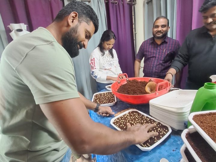 A participant sowing seed into trays of cocopeat during a training session